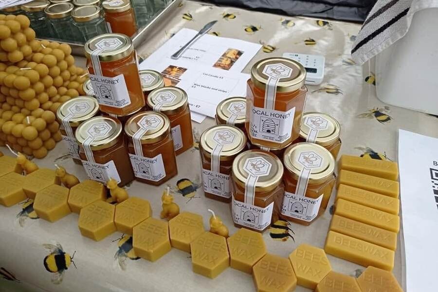 Jars of honey and beeswax products displayed on a table.