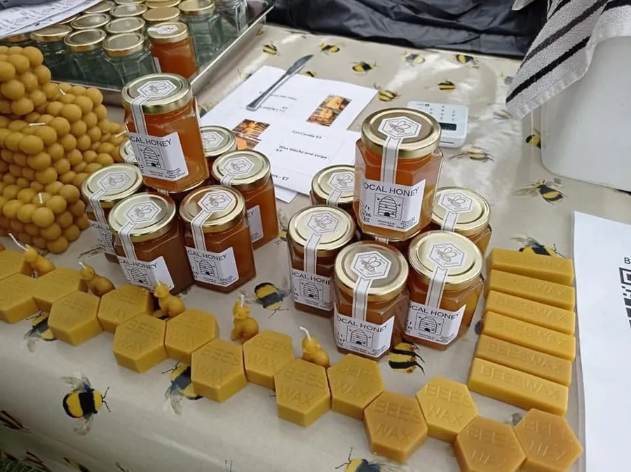 Display of locally produced honey jars and beeswax products.